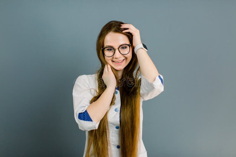 Young smiling woman doctor in big glasses. Portrait of a young female professional cosmetologist. Healthcare occupation royalty free stock photo Young smiling woman doctor in big glasses. Portrait of a young female professional cosmetologist. Healthcare occupation royalty free stock photo
