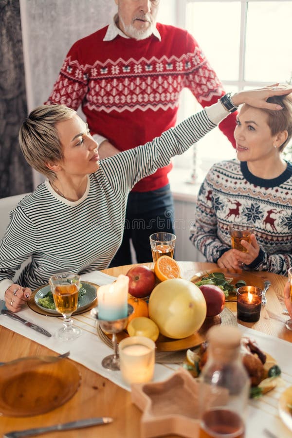Young smiling woman petting her sister during the dinner royalty free stock photos Young smiling woman petting her sister during the dinner royalty free stock photos