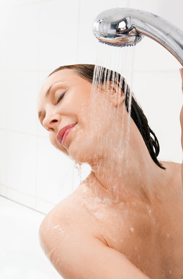 Young smiling woman taking a shower stock photography