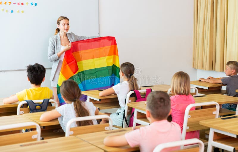 Positive female teacher standing with lgbt flag