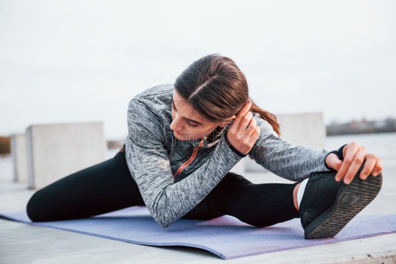 Young Sportive Girl Doing Yoga Exercises on Fitness Mat Outdoors Near ...