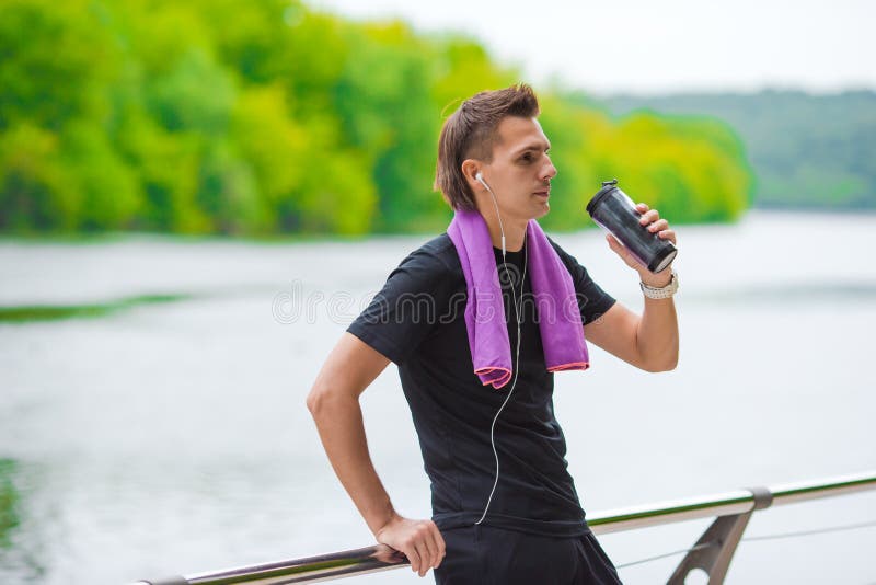 Young sports man with towel and bottle of water