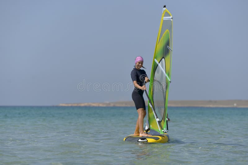Young sports woman Windsurfing at sea on a Sunny day. royalty free stock photos Young sports woman Windsurfing at sea on a Sunny day. royalty free stock photos