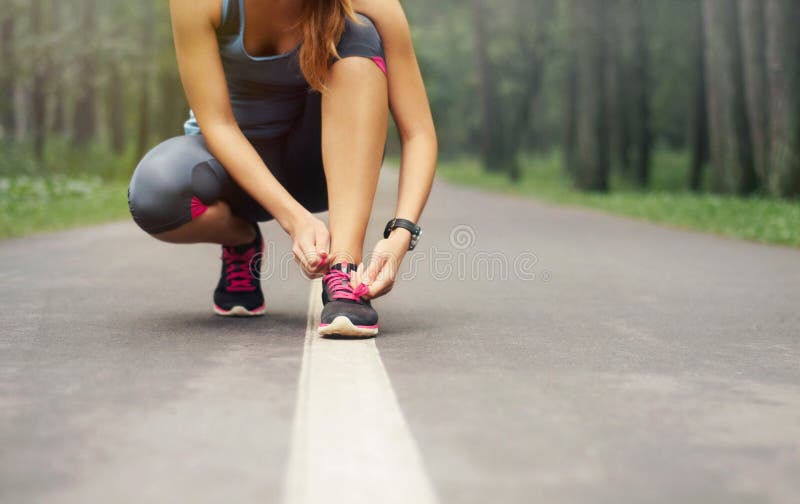 Giovane sportivo donna di preparazione per l'esecuzione dei primi di mattina nebbiosa nella bella natura, foresta, concetto di benessere.