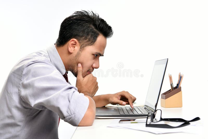 Young business man thinking while working with laptop computer royalty free stock photo