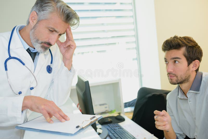 Young stressed male patient consulting with doctor royalty free stock photos Young stressed male patient consulting with doctor royalty free stock photos