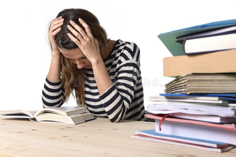 Giovani sottolineato studente ragazza che studia pila di libri sulla libreria scrivania preparazione di MBA di un test o un esame in sensazione di stress stanco e sopraffatto nell'educazione dei giovani concetto.