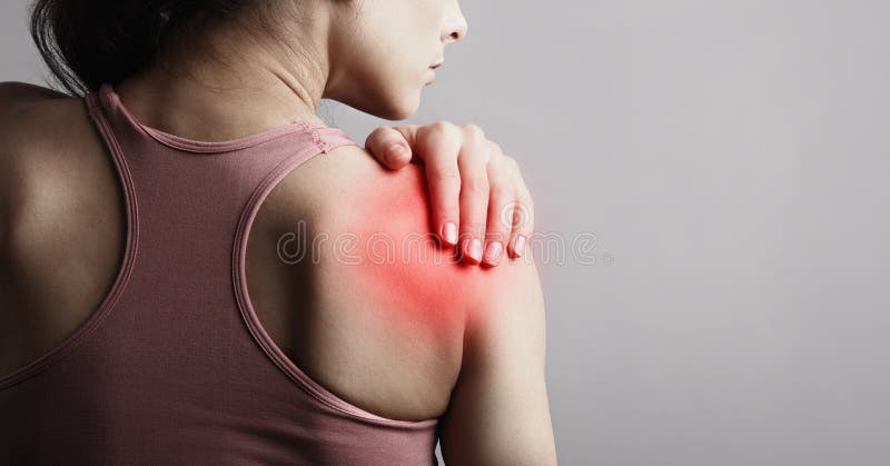 Young strong sporty woman suffering from pain in shoulder in sport wear. Touching the hand. Sports exercising injury. Closeup portrait with highlighted in red and empty copy space. Back view. The concept of medicine, massage, physiotherapy. Young strong sporty woman suffering from pain in shoulder in sport wear. Touching the hand. Sports exercising injury. Closeup portrait with highlighted in red and empty copy space. Back view. The concept of medicine, massage, physiotherapy