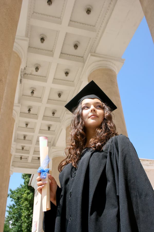 Young student in gown near the university