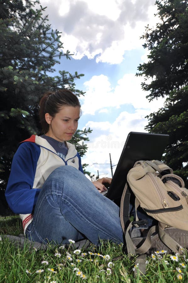 Young student learning outdoors with laptop