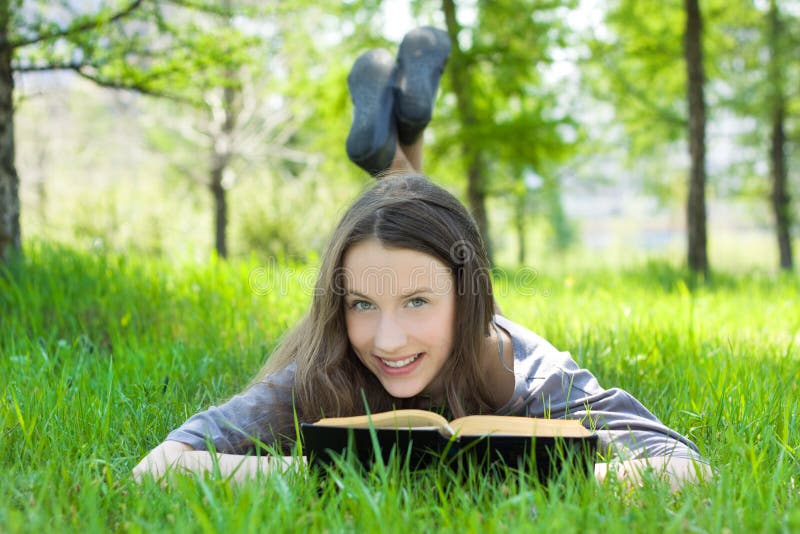 Young student reading book in park