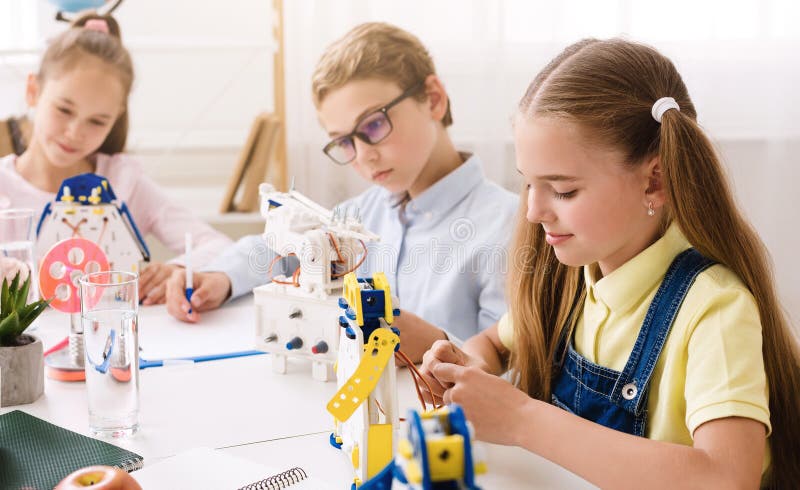 Young Students Build Robots in Classroom Setting royalty free stock images