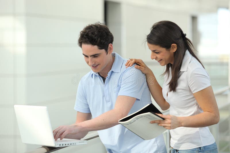 Young students smiling in front of laptop