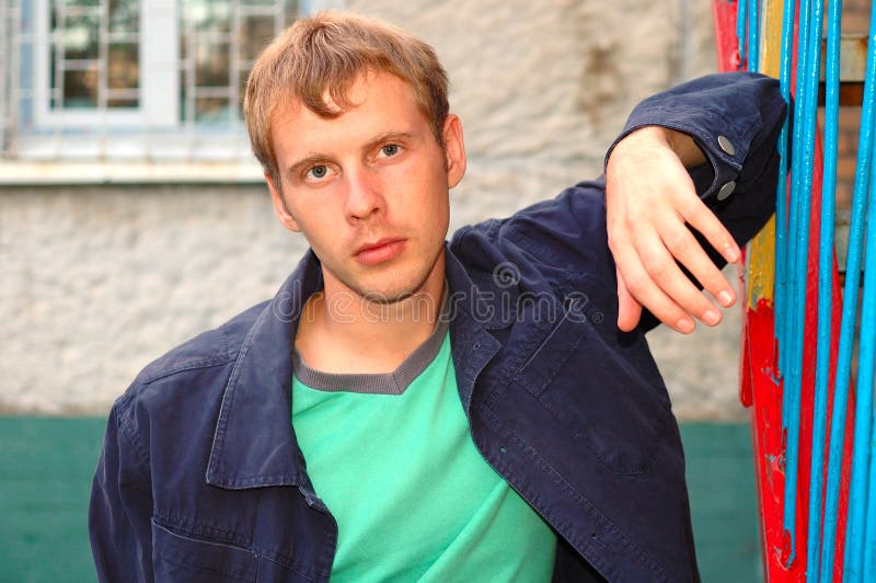 Young stylish man stand near handrail.