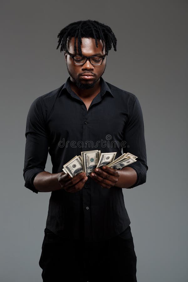 Young successful african businessman holding money over dark background. stock photos Young successful african businessman holding money over dark background. stock photos