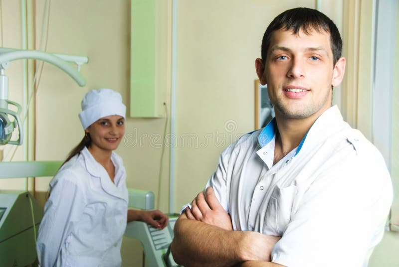 Young successful dentist with his assistant