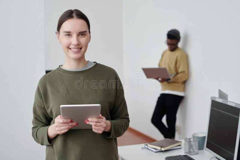 Young successful female programmer or manager with tablet looking at camera stock photos