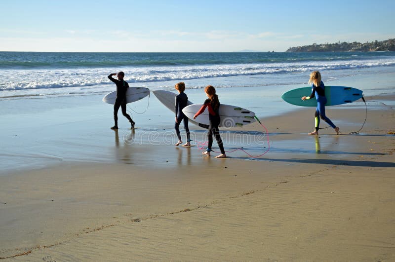 Young surfers head for the surf at Oak Street Beach in Laguna Beach, California. stock images Young surfers head for the surf at Oak Street Beach in Laguna Beach, California. stock images