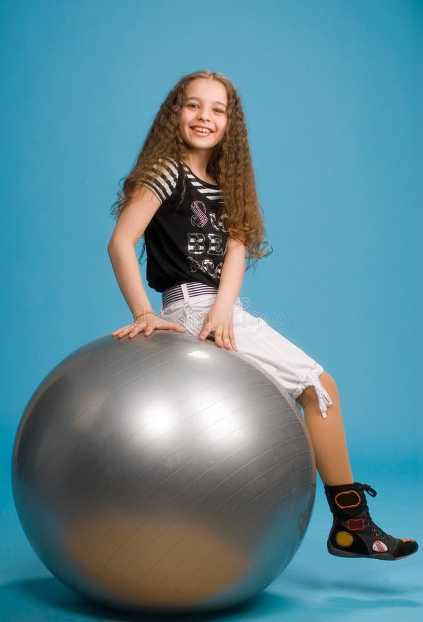 Young sweet girl on a big grey ball