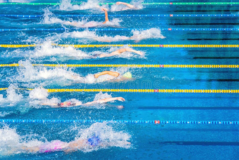 Young swimmers in outdoor swimming pool during competition. Health and fitness lifestyle concept with kids.