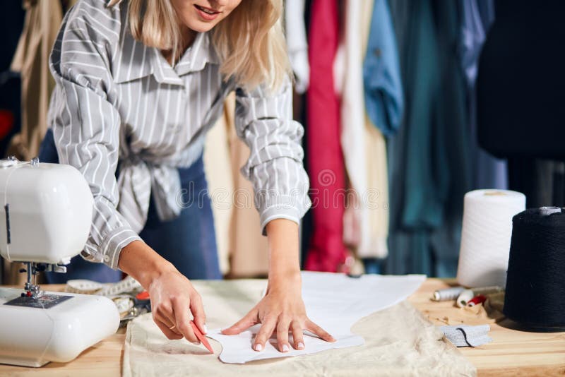 Young talented creative female fashion designer working on her designs in studio royalty free stock photography Young talented creative female fashion designer working on her designs in studio royalty free stock photography