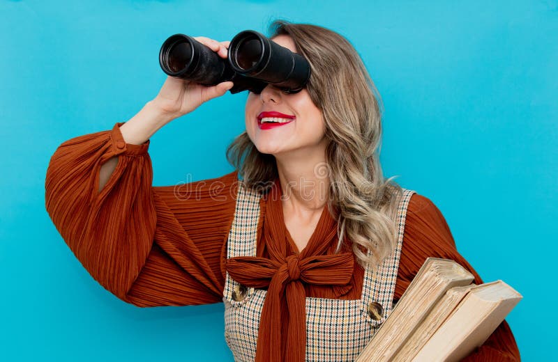 Young teacher with books and binocular