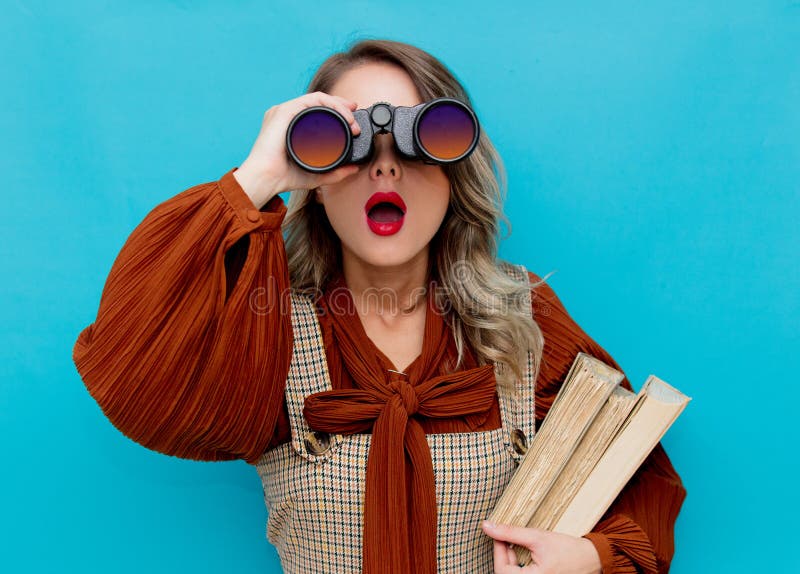 Young teacher with books and binocular