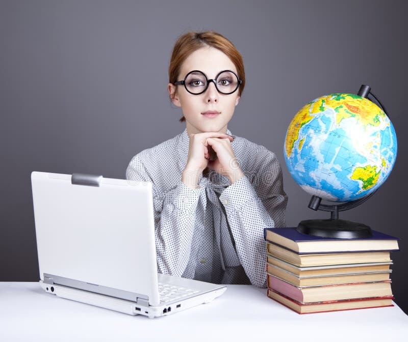 The young teacher with books, globe and notebook.