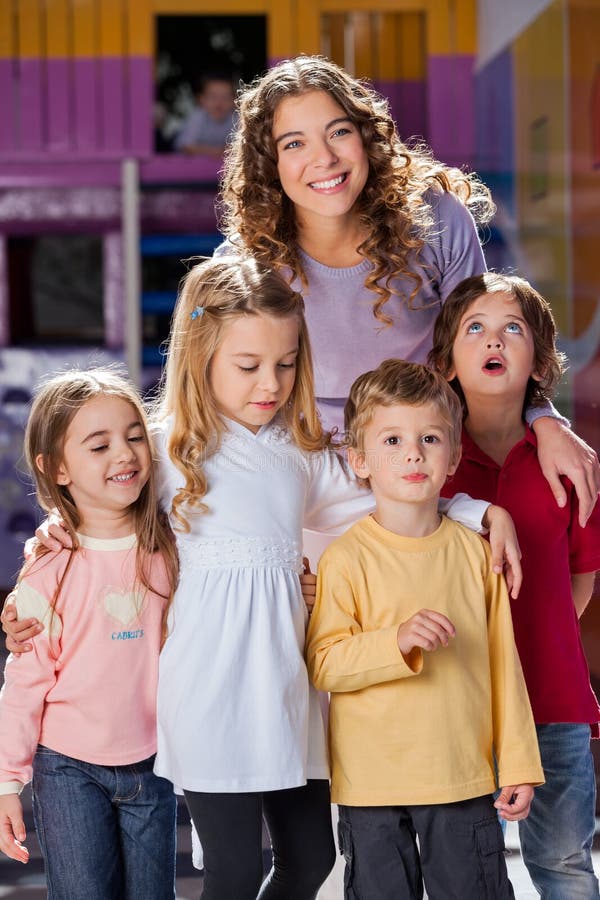 Young Teacher With Children In Kindergarten stock photo