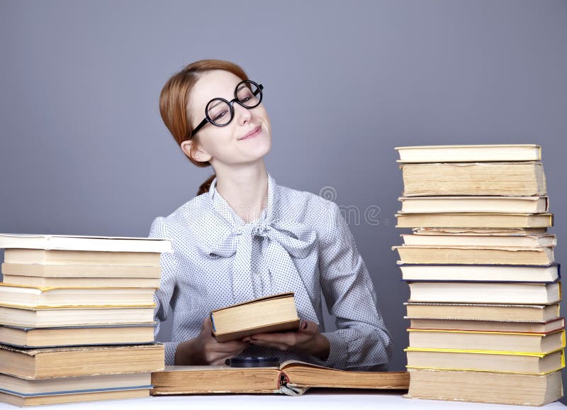 The young teacher in glasses with books.