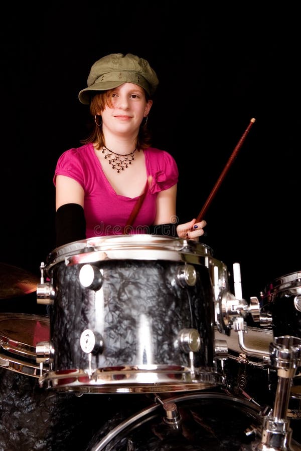Young teenage girl playing drums. Isolated on black. Young teenage girl playing drums. Isolated on black.