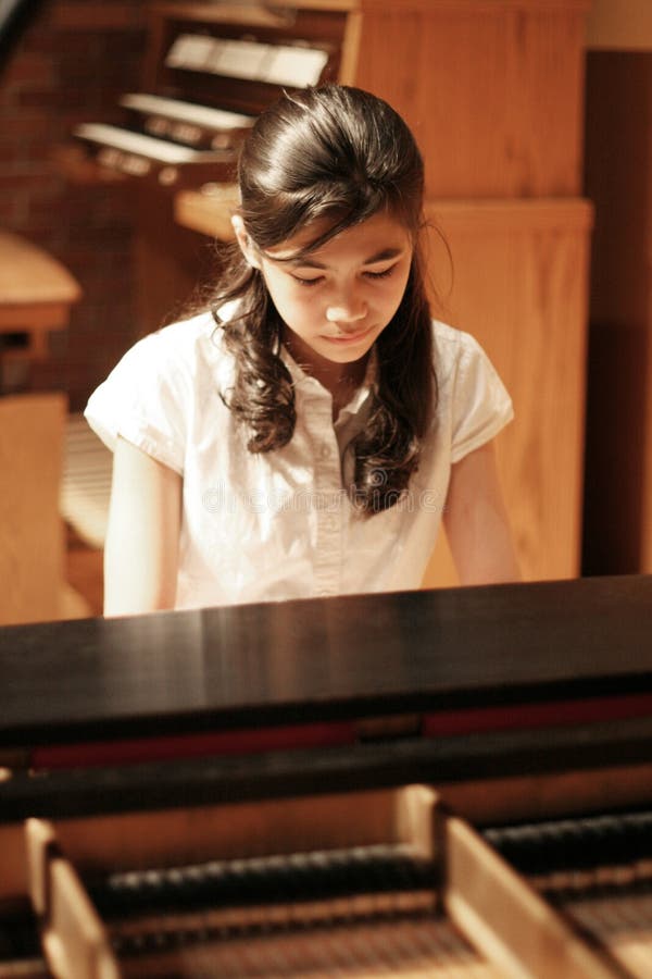 Young teen girl playing piano