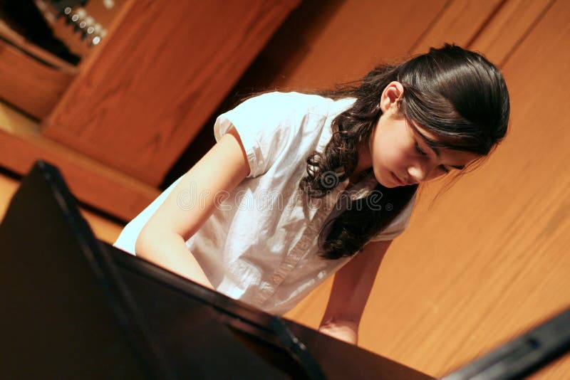 Young teen girl playing piano