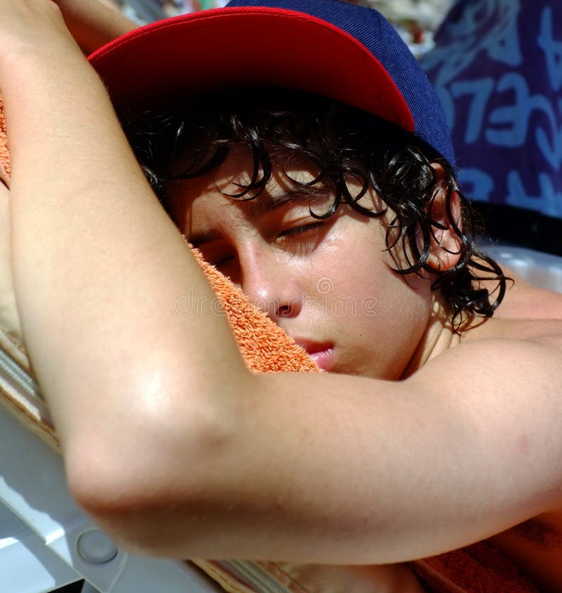 Young teenage boy sleeping on beach