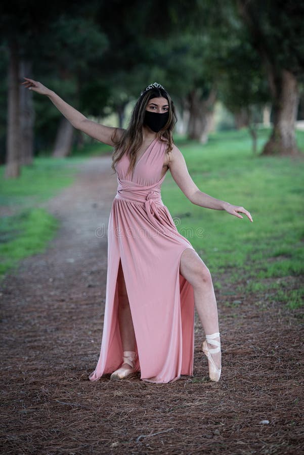 Teenage woman dancing ballet outdoors wearing protective face mask for protection from  Covid-19 Pandemic