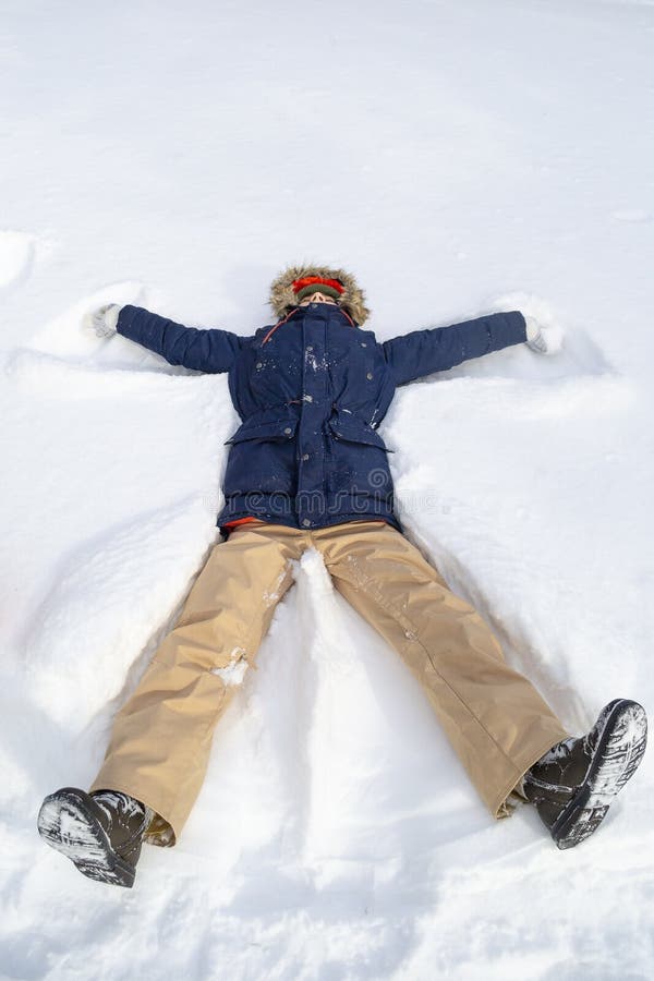 Young teenager boy makes figures on snow and has fun. Active lifestyle, winter activity, outdoor winter games royalty free stock image Young teenager boy makes figures on snow and has fun. Active lifestyle, winter activity, outdoor winter games royalty free stock image
