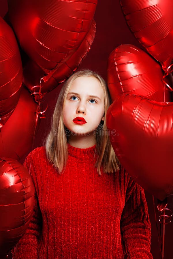 Young teenager girl with balloons red heart dreaming on love