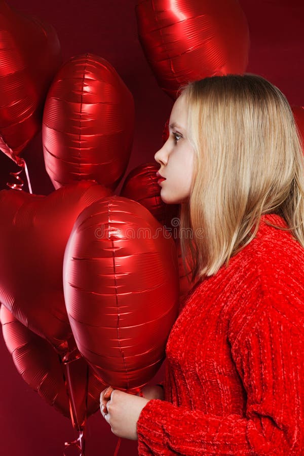 Young teenager girl with balloons red heart