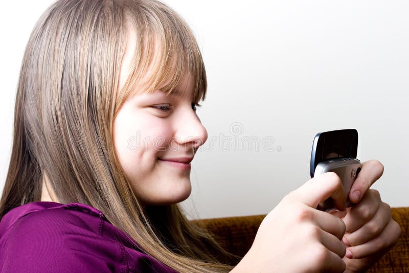 Young teenager girl holding mobile phone texting royalty free stock photo Young teenager girl holding mobile phone texting royalty free stock photo