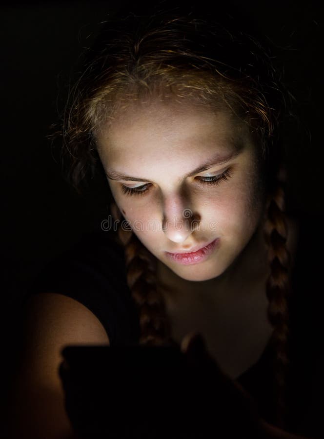 Young Teenager Redhead Girl With Long Hair With Smartphone In Dark Room