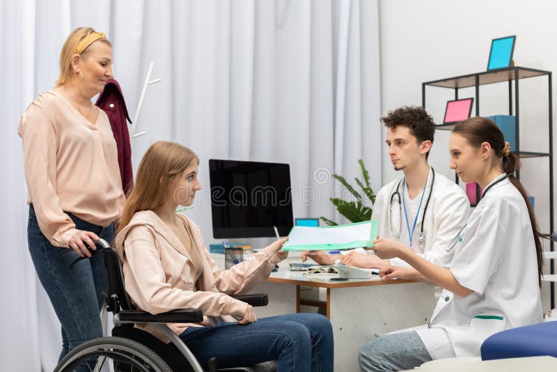 The mother brought the teen in a wheelchair to the doctor&x27;s room. The teen passes the test results to the nurse