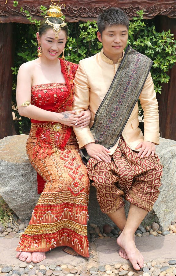 Young Thai Couple In Traditional Outfit Sitting And Posing