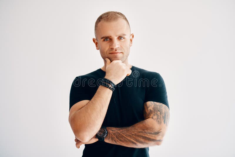Young thoughtful man thinking and looking to camera on white background stock image