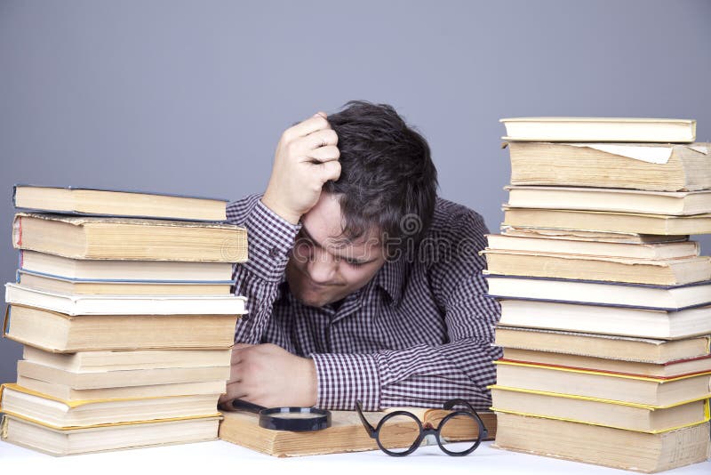 The young tired student with the books isolated.