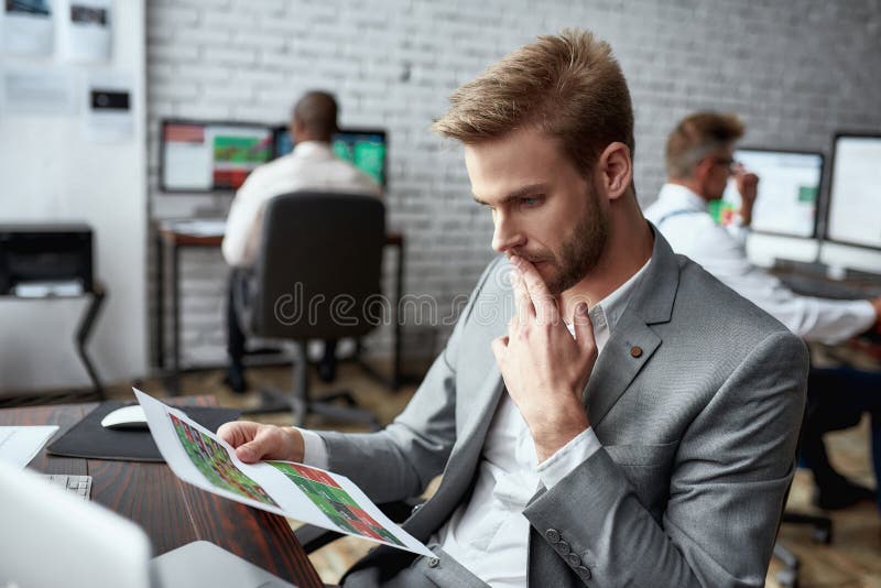 The Right Way of Trading. Young Trader Sitting by Desk and Looking Seriously at Analytical
