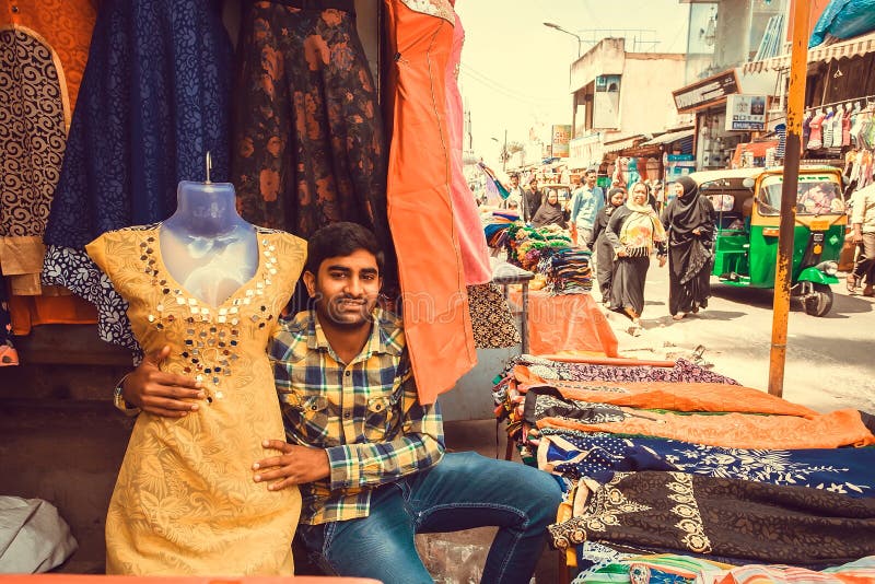 Young trader working with female fashion in textile store of busy market street royalty free stock photography Young trader working with female fashion in textile store of busy market street royalty free stock photography