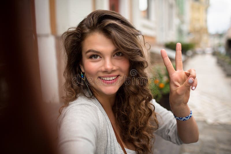 Young travel girl, having fun showing fingers on selfie photo. stock photo Young travel girl, having fun showing fingers on selfie photo. stock photo