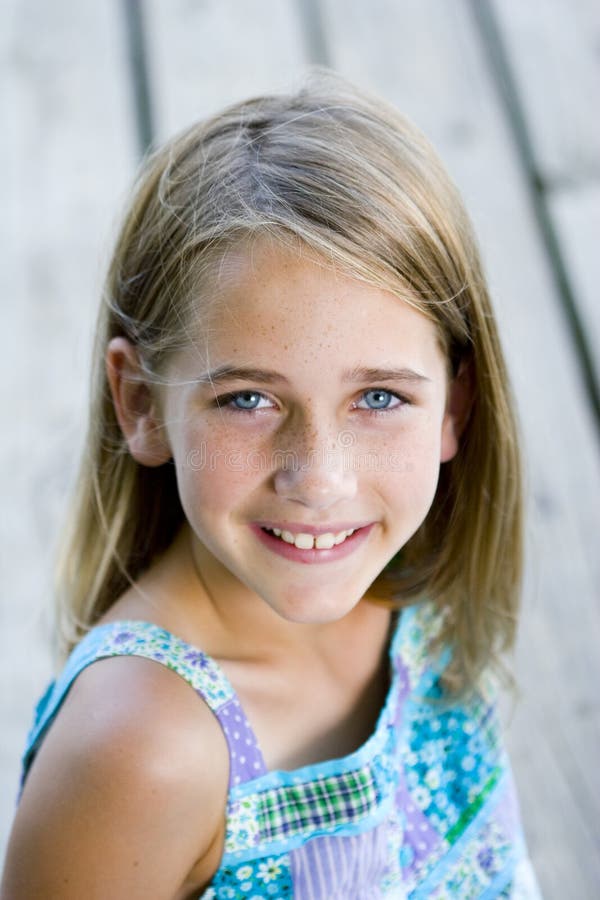 Young tween girl sitting on a pier