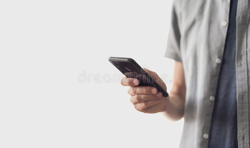 Young using smart phone. Businessman texting on mobile phone isolated on grey background royalty free stock photography