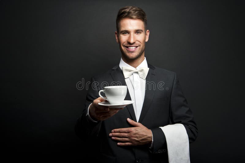 Young waiter in uniform serving hot coffee